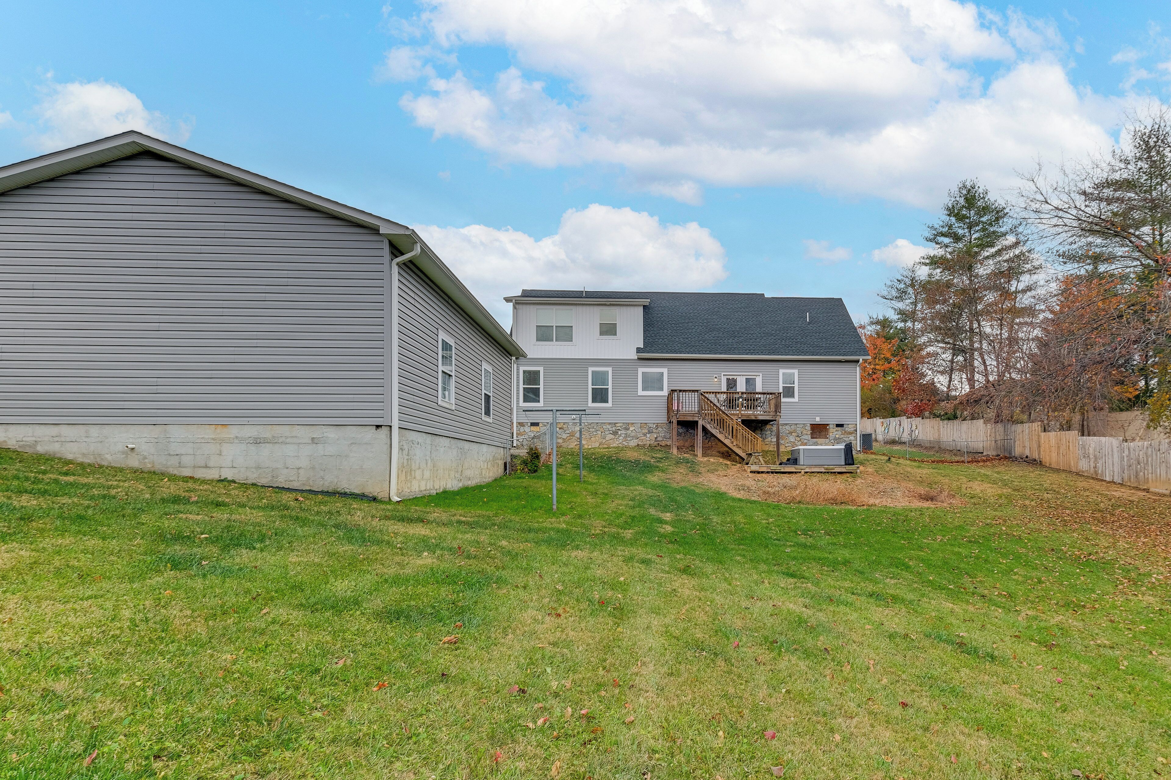 A two-story house with a covered porch and a fenced yard.