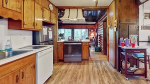 Una cocina con armarios de madera, lavavajillas y estufa.