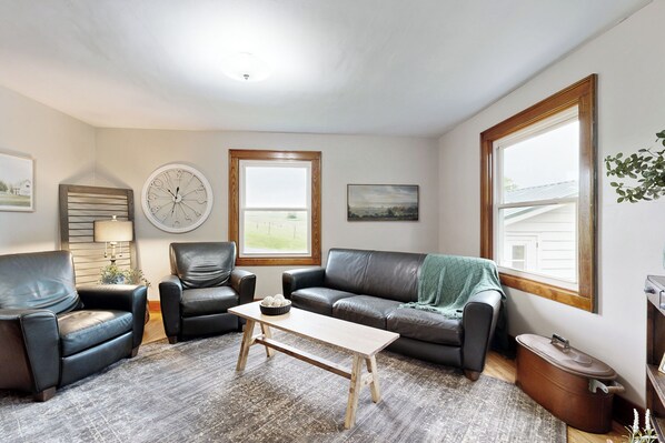 A living room with a sofa, two armchairs, a coffee table, a clock, and a window with a view. - Bring Your Pup! Historic Family Home in Darlington (Darlington)
