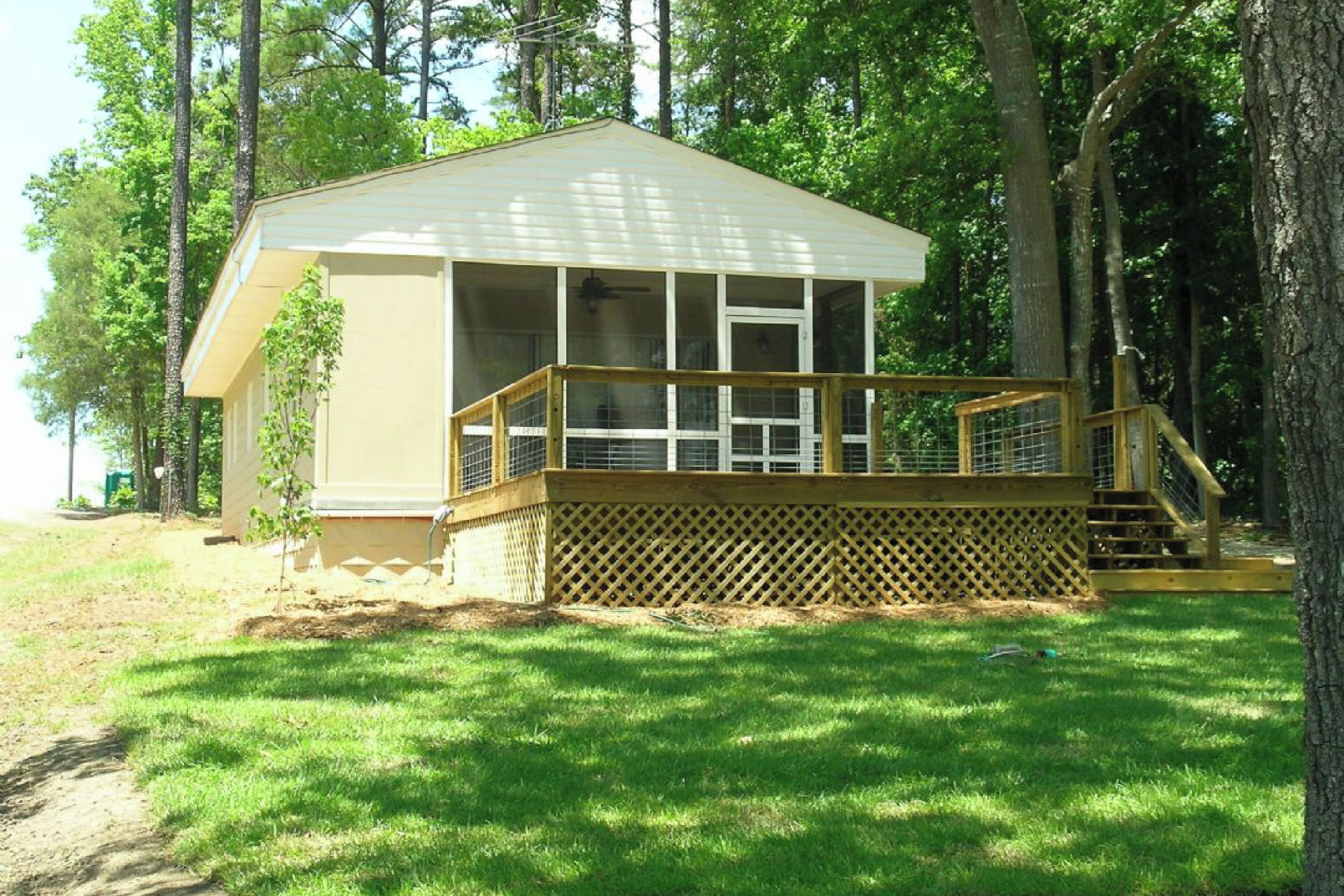 Une petite cabane à un seul étage, dotée d’une terrasse et d’un escalier menant à un porche abrité.