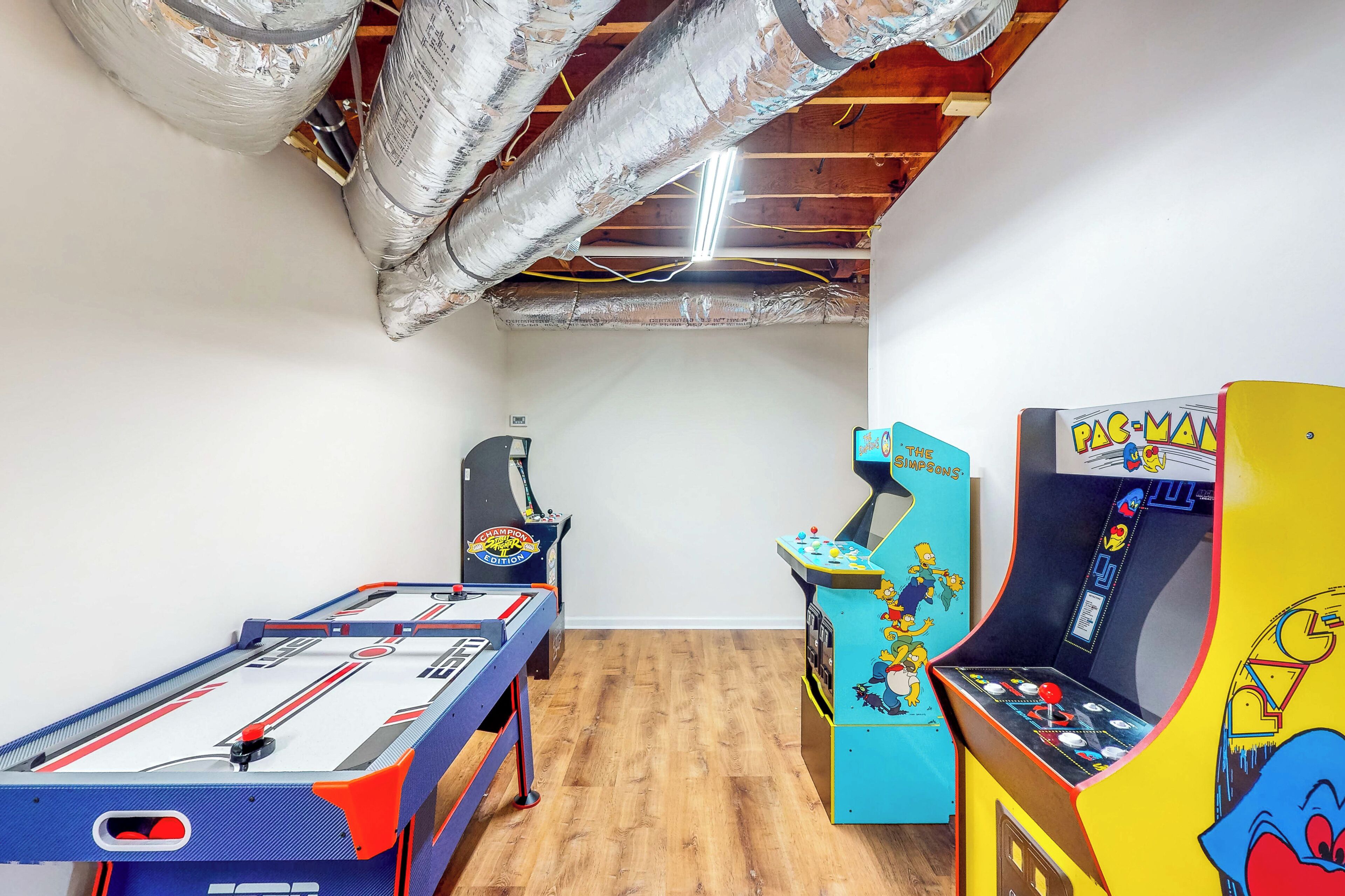 Una stanza con un tavolo da calcio, una macchina arcade e una macchinetta per il flipper.