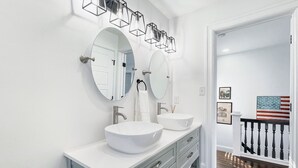 A modern bathroom with two large round mirrors, a white sink, and a vanity with drawers. - Pets Welcome! Family-friendly Retreat in Culpeper (Culpeper)