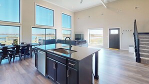A spacious kitchen with a central island, large windows, and a ceiling fan. - Lakefront Oasis w/ Water Toys! Breckenridge Home (Breckenridge)