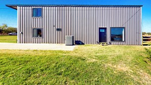 A modern industrial-style building with a flat roof, vertical siding, and a central door. - Lakefront Oasis w/ Water Toys! Breckenridge Home (Breckenridge)
