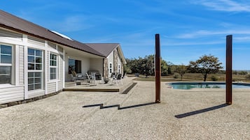 A house with a patio, outdoor seating, and a swimming pool.