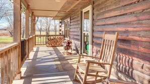 A log cabin with a porch, wooden rocking chairs, and a view of the surrounding landscape. - 'mule Creek Lodge' Rural Stay Near Coldwater Lake (Wilmore)