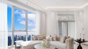 Ein modernes Wohnzimmer mit großem Fenster, einer Couch, einem kleinen Tisch und Blick auf die Stadtlandschaft.