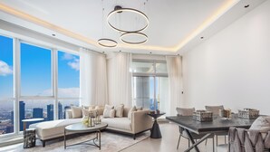 Ein modernes Wohnzimmer mit Sofa, Esstisch und großen Fenstern mit Blick auf die Stadt.