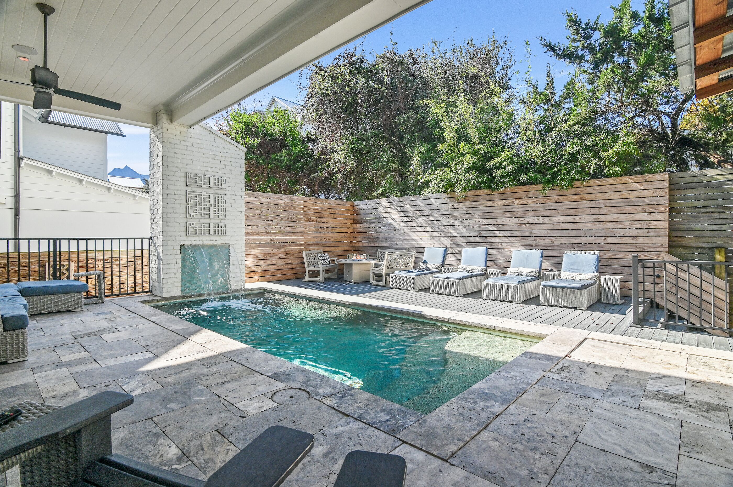 A swimming pool with lounge chairs and a wooden deck.
