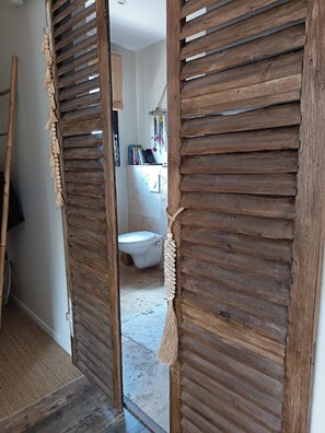 A wooden door with a macramé decoration and a broom leaning against the wall. - Villa among oaks and pines 30 minutes from Mont Ventoux (Faucon)