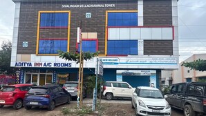A building with multiple businesses including 'Aditya Inn A/C Rooms' and 'New Holland Agriculture'. - Aditya Inn (Krishnagiri)