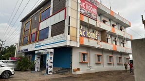 A multi-story building with signage for 'Aditya Inn' and 'A/C Rooms'. - Aditya Inn (Krishnagiri)
