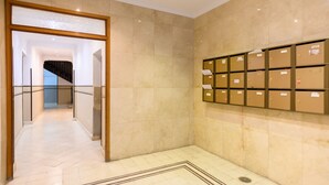A hallway with a marble floor, a glass railing, and a wall of storage boxes. - Spacious 2-bedroom flat in the centre of Madrid. (Madrid)