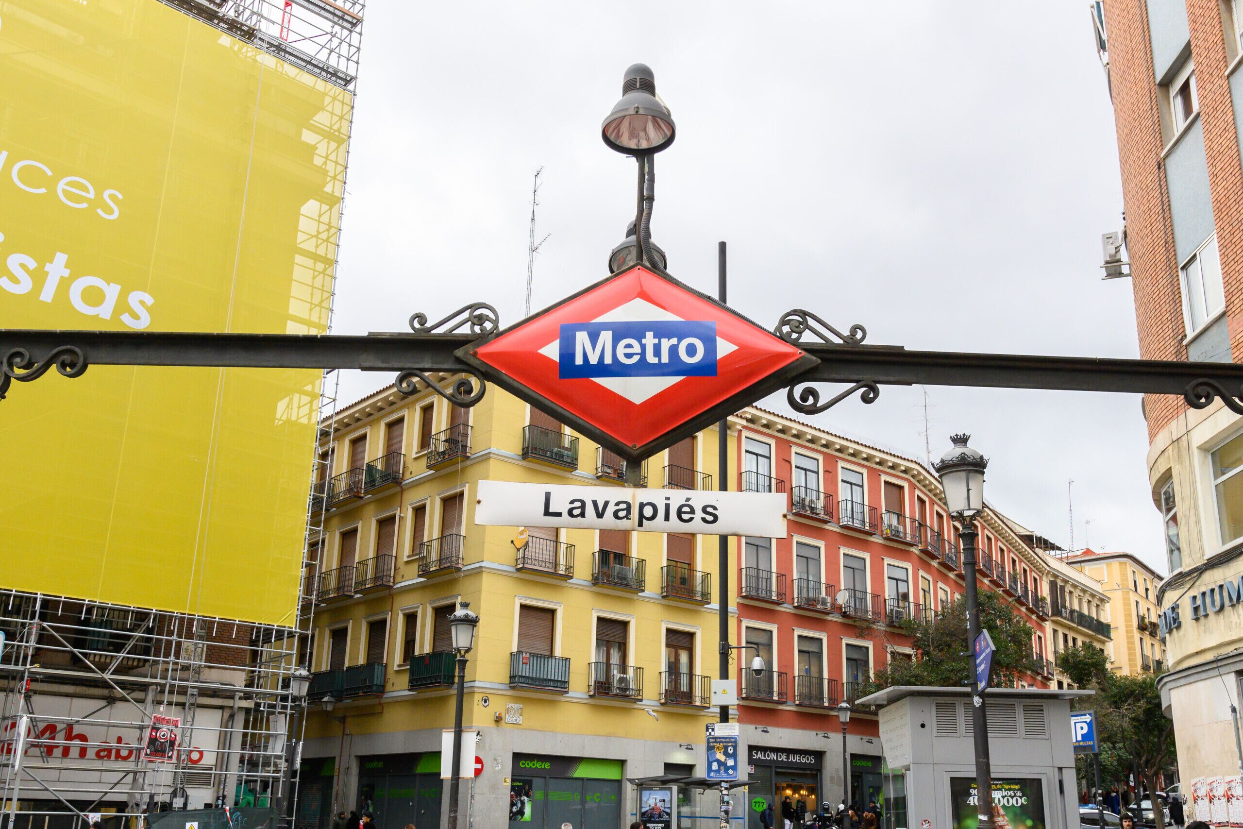 A street sign for Metro Lavapiés with a yellow building in the background.