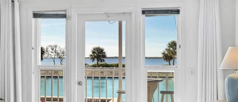 A hotel room with a view of a pool and a beach.