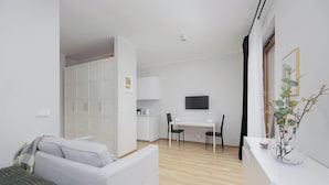 Een moderne, goed verlichte kamer met een bed, een bureau en een televisie.