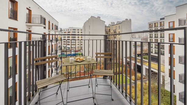 Een balkon met een tafel, stoelen en een bank.