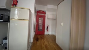 A hallway with a white refrigerator, a red door labeled 'Telephone,' and a fire extinguisher on the wall. - Central London (9) Apartment - Hyde Park (Greater London)