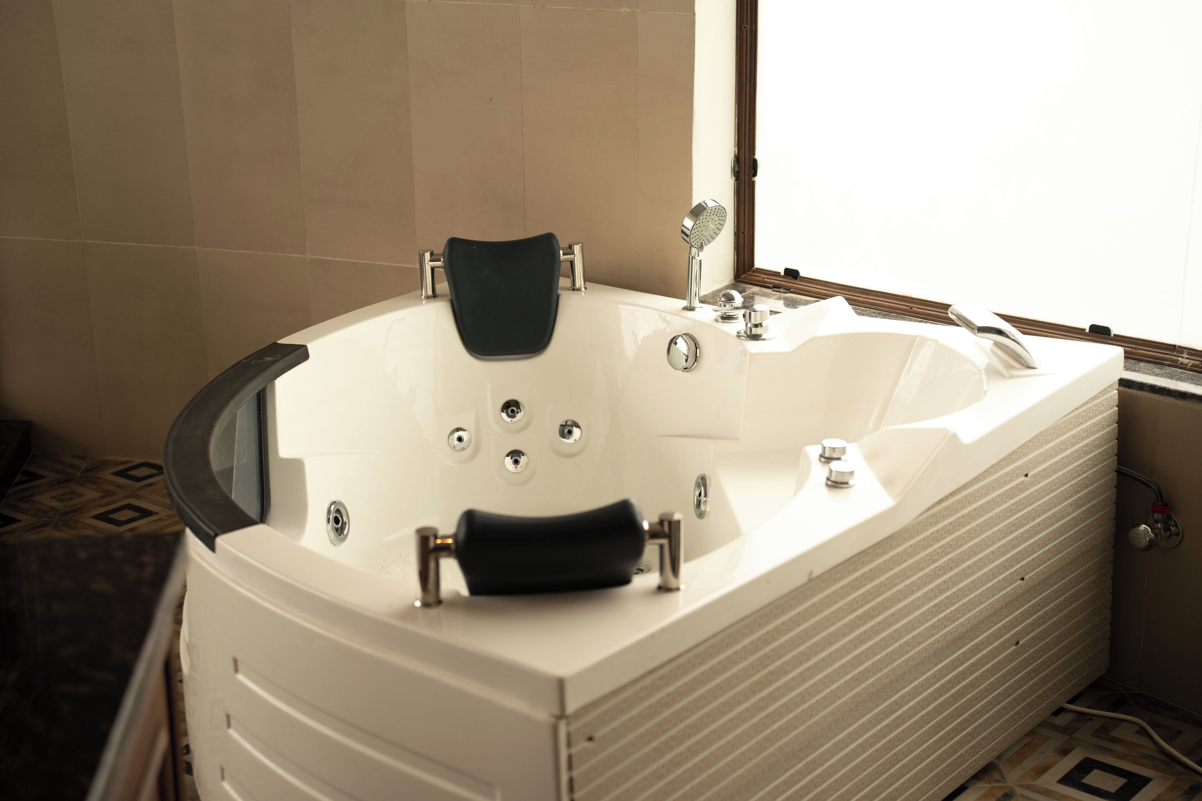 Une salle de bain moderne avec une baignoire sur pieds, un miroir et une fenêtre laissant entrer la lumière naturelle.