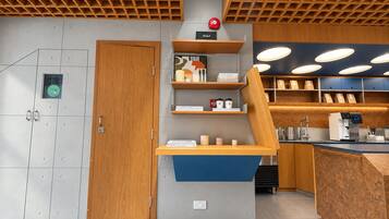 Un intérieur moderne avec une porte en bois, un comptoir bleu et des étagères remplies de divers objets.