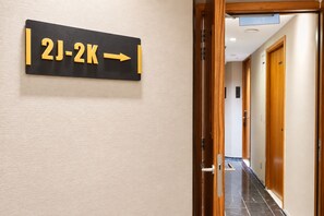 A hallway with a directional sign indicating room numbers 2J-2K. - Aura Hotel Purvis (Singapore)