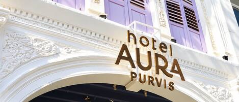 A hotel sign with the name 'hotel AURA PURVIS' in a classic architectural style with ornate detailing.