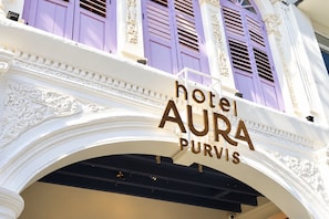 Letrero de hotel con el nombre 'hotel AURA PURVIS' en un estilo arquitectónico clásico con detalles ornamentales.