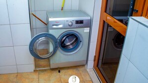 Une buanderie moderne et compacte, équipée d’un lave-linge et d’un sèche-linge à chargement frontal.