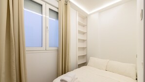 A bedroom with a bed, a window, and built-in shelving. - M Scsd14 Amplio Piso Exterior de 2 Dormitorios e (Madrid)