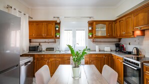 Eine moderne Küche mit Holzausstattung, Edelstahlgeräten und einer zentralen Kochinsel mit einem Blumentopf.