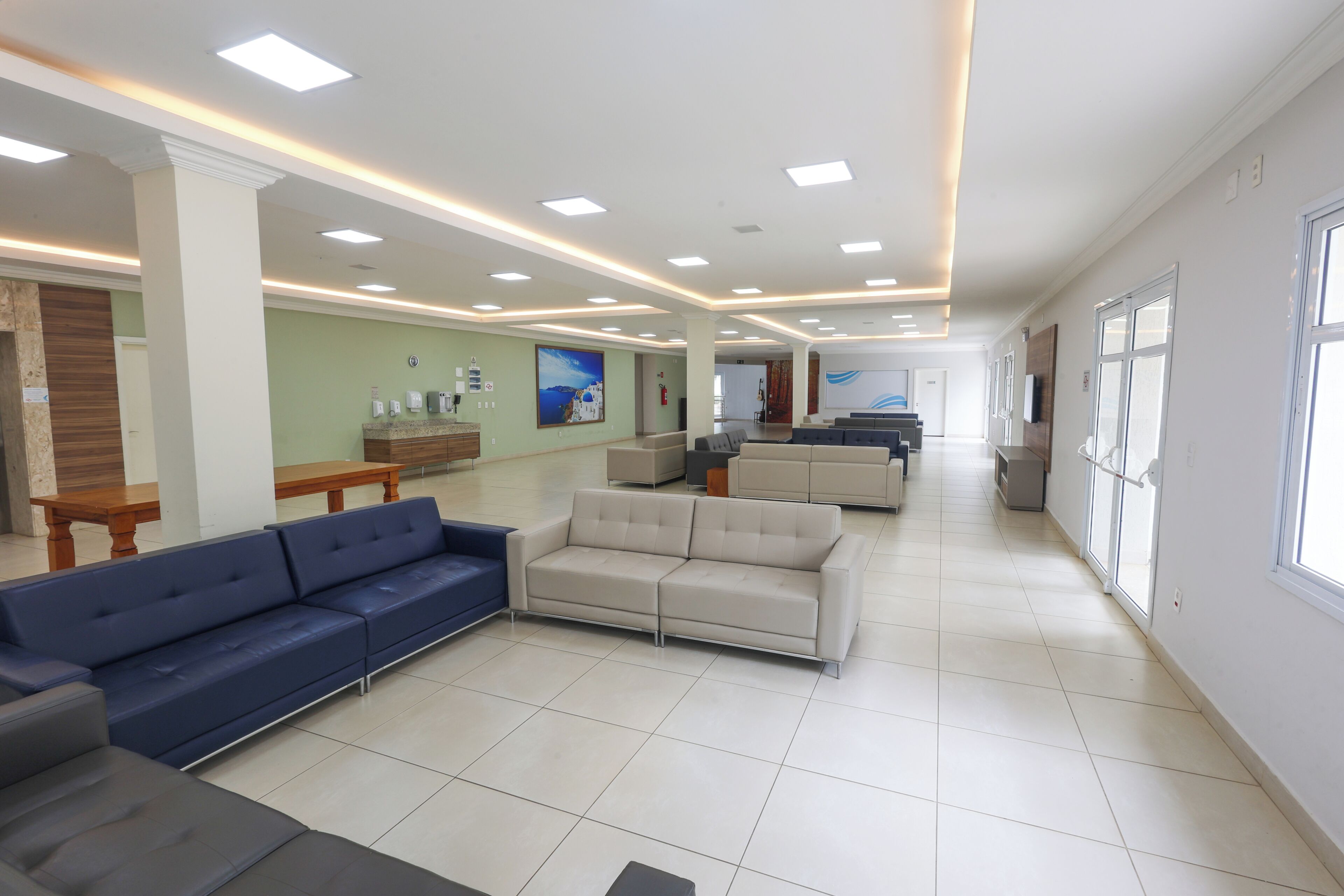 A spacious lobby with seating areas, a reception desk, and a large window providing natural light.
