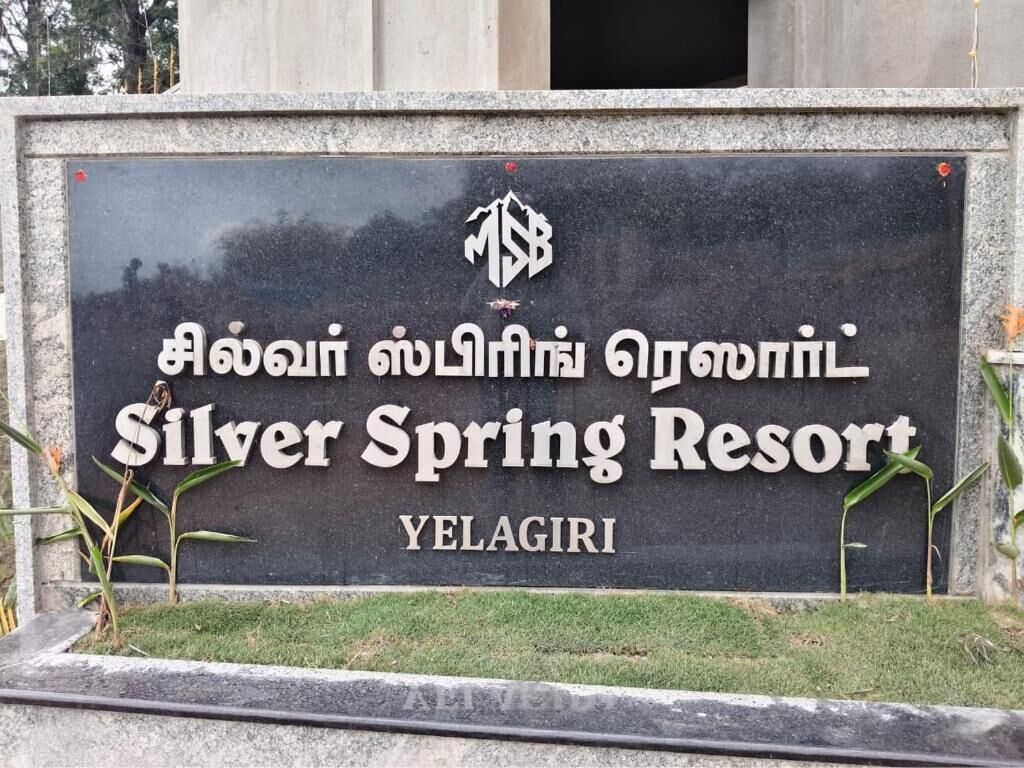 Une enseigne pour le Silver Spring Resort à Yelagiri, avec un logo et un texte en anglais et en tamoul.