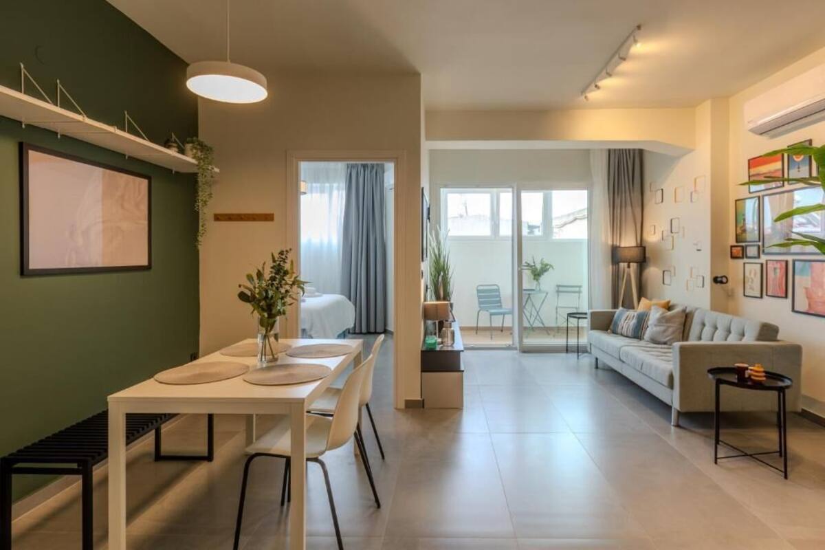 Un soggiorno moderno con zona pranzo, divano e tavolino.