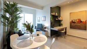 A modern dining area with a round table, chairs, and a large potted plant. - The Next Chapter Nilie Hospitality MGMT (Thessaloniki)