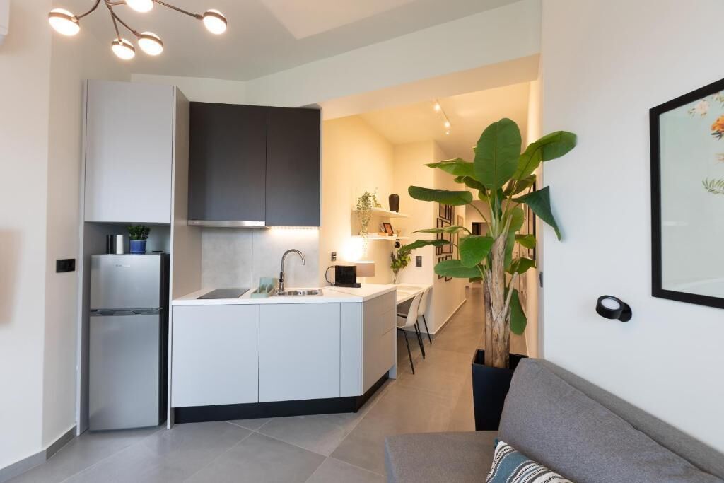Una cocina moderna con una isla integrada, un refrigerador y un comedor con mesa y sillas.