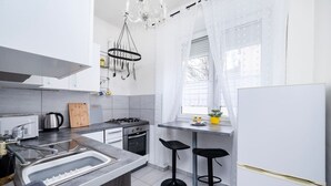 Une cuisine moderne équipée d’une cuisinière à gaz, d’un évier et de tabourets de bar.