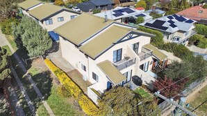 A residential building with multiple units, each featuring a balcony and solar panels on the roof. - Albi Celeste - 2/9 Park Road (Jindabyne)