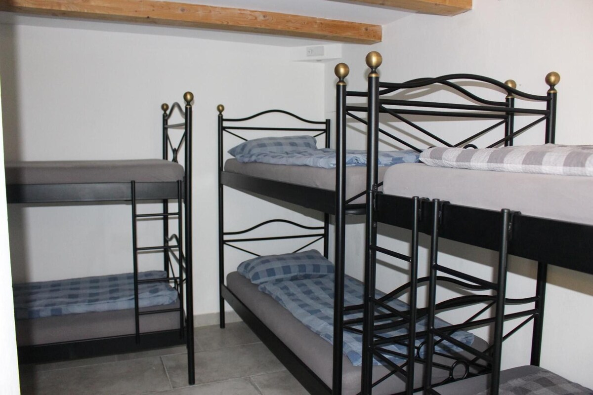 Ein Stockbett mit einem Holzkopfstück und einem Metallgestell.