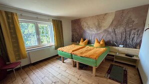 Una habitación con una cama, una ventana, un radiador, un escritorio y una silla.