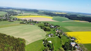 Vista aérea de una zona rural con campos, un pequeño pueblo y casas dispersas.