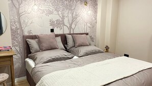 A bedroom with a curved headboard, a bed with multiple pillows, a bedside table, and a lamp. - Apartment "Fewo Sand 10 – Large" with Shared Terrace, Garden & Wi-Fi (Bamberg)
