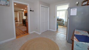 A spacious kitchen with a refrigerator, microwave, and dining area. - Private Orleans Getaway Near Bakers Pond & Beaches (2422) (Orleans)