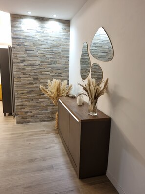 A reception area with a stone wall, a wooden reception desk, and decorative pampas grass. - Charming, recently renovated apartment in a central neighborhood with excellent public transportation access (Roma)