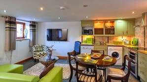 A compact living space with a dining area, kitchen, and seating area. - Lime Cottage, Great Houndbeare Farm (Aylesbeare)