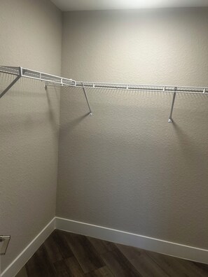 Ein Eckschrank mit einem Wäscheständer aus Metall und Holzboden.