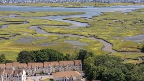 A coastal hotel with multiple buildings, a marshy landscape, and a view of the sea. - Perfect Wells Maine getaway, Village by the Sea Condo! (Wells)