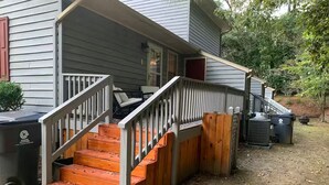Une maison avec un escalier en bois menant à une véranda.