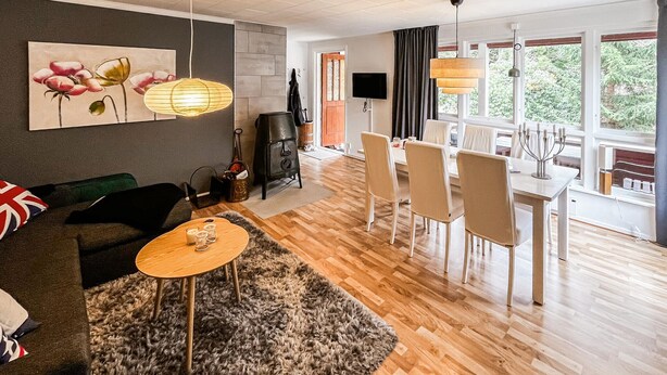 A modern living room with a sofa, coffee table, and artwork, a dining area with chairs and a table, and a fireplace. - 2 bedroom awesome home in Sösdala (Sösdala)