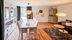 A dining area with a table and chairs, a cabinet, a sofa, and a view through a window. - 2 bedroom awesome home in Sösdala (Sösdala)