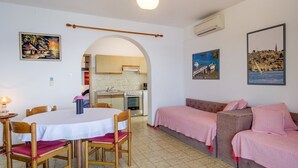 Een gezellig, compacte ruimte met een eethoek, kitchenette en een slaapbank.